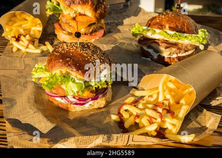 Trois hamburgers aux frites trempés dans une sauce ketchup prête à manger Banque D'Images