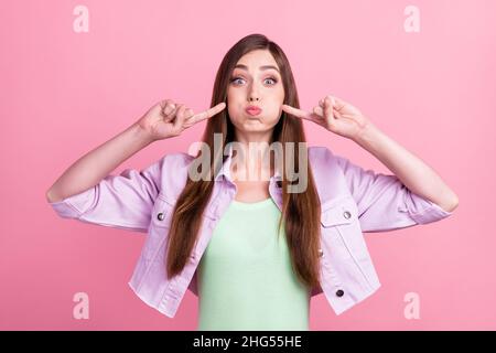 Photo portrait femme tenant ait dans les joues pointant les doigts isolé pastel couleur rose fond Banque D'Images