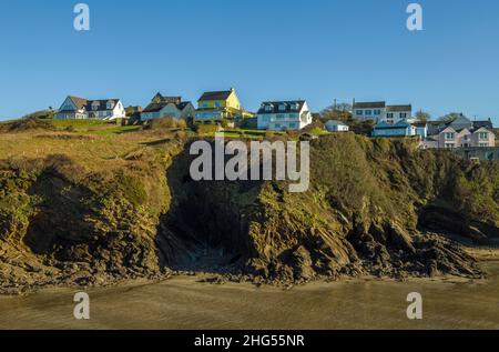 Vue sur la plage de Little Haven jusqu'aux maisons en haut de la falaise sur la côte de Pembrokeshire dans l'ouest du pays de Galles, le jour de janvier ensoleillé Banque D'Images