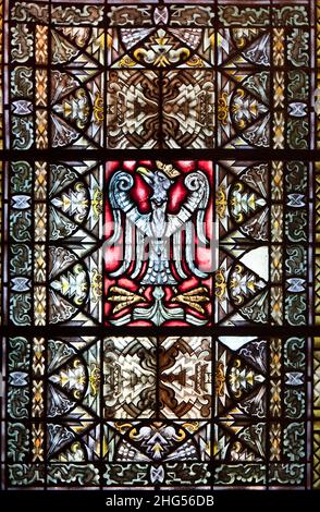 Gniezno, Pologne - ancien emblème national polonais, aigle blanc sur fond rouge. Vitraux dans la cathédrale du coroner. Banque D'Images