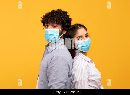 Combattre ensemble la pandémie.Jeune couple indien portant des masques médicaux de protection, debout dos à dos Banque D'Images
