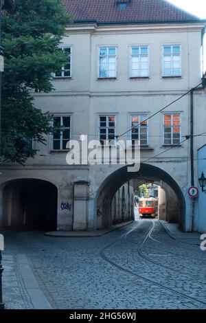 PRAGUE, RÉPUBLIQUE TCHÈQUE - 5 juin 2018 : un vieux tramway dans les rues de la ville vu par un couloir sous un ancien bâtiment dans une rue étroite Banque D'Images