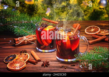 Vin rouge de Noël chaud aux épices aromatiques et aux agrumes sur une table rustique en bois, en gros plan.Boisson chaude traditionnelle à Noël ou ne Banque D'Images