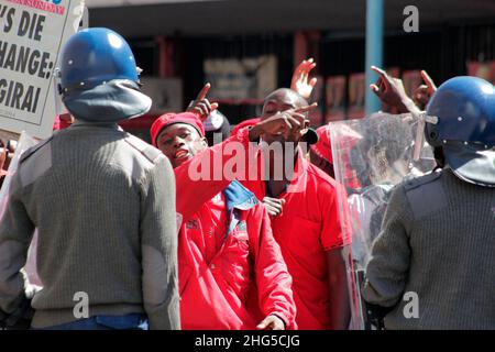 Un partisan du parti d'opposition, le MDC, affronte la police dans le quartier des affaires central de Harare.Le MDC est le principal parti d'opposition du Zimbabwe et a souvent refusé le droit de manifester.Zimbabwe. Banque D'Images