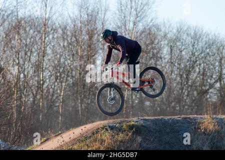 Homme à vélo BMX sautant sur des collines et des obstacles sur la piste de saut à vélo d'Edenbrook Country Park, Fleet, Hampshire, Royaume-Uni Banque D'Images