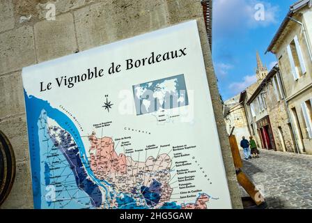 Carte des vins de Saint-Émilion Bordeaux sur le mur de la boutique de vins avec un couple explorant le village viticole historique de Saint-Émilion Gironde Bordeaux France Banque D'Images