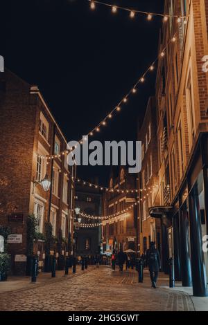 Londres, Royaume-Uni - 23 novembre 2021 : personnes marchant sous les ficelles des lumières de Noël à Covent Garden, une célèbre zone touristique de Londres avec beaucoup de SH Banque D'Images