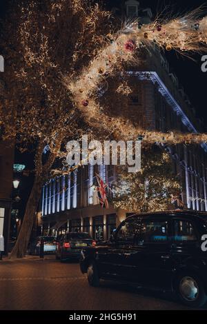 Londres, Royaume-Uni - 23 novembre 2021: Taxi conduit sous les feux de Noël autour de la colonne dans Seven Dials, une célèbre jonction de route à Covent Garden, un Banque D'Images