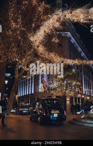 Londres, Royaume-Uni - 23 novembre 2021: Taxi conduit sous les feux de Noël autour de la colonne dans Seven Dials, une célèbre jonction de route à Covent Garden, un Banque D'Images