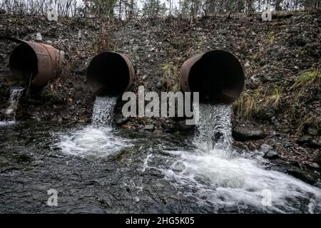 Gouttière. Ruissellement d'eau provenant d'un déversoir routier (évacuation de l'eau, évacuation des eaux pluviales), de deux tuyaux et d'eau à écoulement lent (ruissellement direct) Banque D'Images