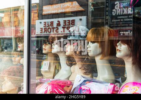 The Bronx, New York City, New York, États-Unis.2 novembre 2021.Perruques sur les têtes de mannequin dans une fenêtre de magasin. Banque D'Images