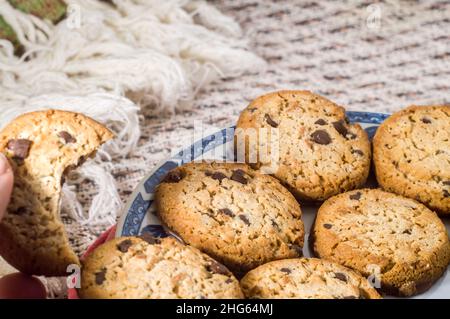 biscuits sur une assiette avec une tasse floue dans l'arrière-plan et gouttes de café tombant, copier l'espace Banque D'Images