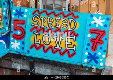 Washington Heights, Manhattan, New York City, New York, États-Unis.4 novembre 2021.Fresque disant « Spread Love » sur une porte d'accès au sous-sol dans la ville de New York. Banque D'Images