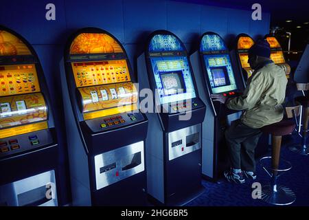 Homme senior jouant À Une machine à sous. Banque D'Images