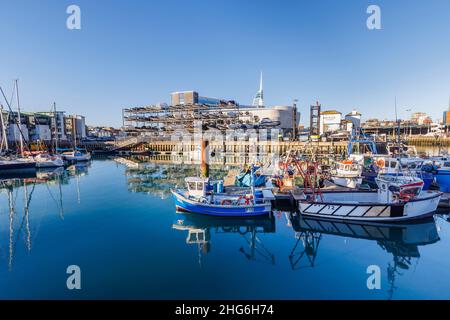 Des bateaux de pêche amarrés et drystack dans Camber Quay dans Portsmouth Harbour, Hampshire, côte sud de l'Angleterre avec des réflexions sur une journée ensoleillée Banque D'Images