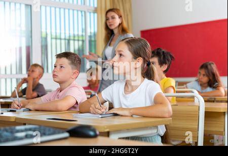 Entre les élèves, il fait des notes sur la conférence de l'enseignant Banque D'Images