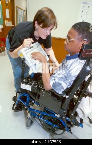 New Jersey East Orange, centre de paralysie cérébrale, fauteuil roulant électrique handicapé, femme étudiante, thérapeute, clavier d'ordinateur communicateur de garçon noir Banque D'Images