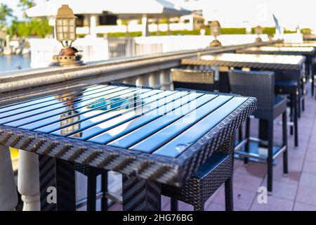 Naples, Floride personne de restaurant extérieur vide café soleil coucher de soleil par la marina quai quai près de Bayfront place avec chaises de table tables près du rail Banque D'Images