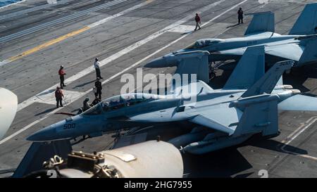 220115-N-AV223-1007 MER DE CHINE DU SUD (JANV15, 2022) les marins se préparent à déplacer un rowler EA-18G, affecté aux “Gauntlets” de l’escadron d’attaque électronique (VAQ) 136, à gauche,Et un F/A-18E Super Hornets, affecté aux « Stingers » du Strike Fighter Squadron (VFA) 113, sur le pont de vol du porte-avions de la classe Nimitz USS Carl Vinson (CVN 70), le 14 janvier 2022.Carl Vinson Carrier Strike Group est en cours de déploiement prévu dans la zone d'exploitation de la flotte américaine 7th afin d'améliorer l'interopérabilité par le biais d'alliances et de partenariats tout en servant de force de réponse prête à l'emploi pour soutenir un Indo-P libre et ouvert Banque D'Images