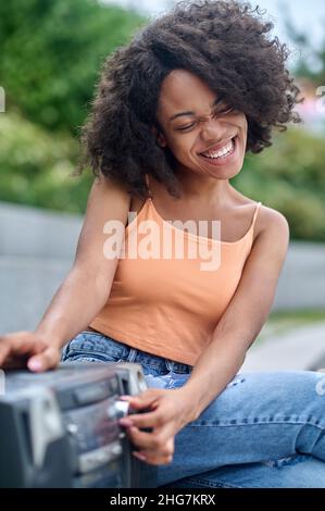 Femme souriante aux yeux fermés, écoutant de la musique Banque D'Images