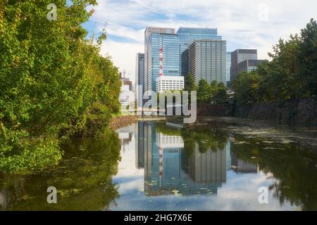 La vue de la lande Hirakawa autour du Palais impérial de Tokyo avec le pont Hirakawabashi et les gratte-ciels du quartier de Marunouchi qui se réfléchissent dans l'eau.Toky Banque D'Images