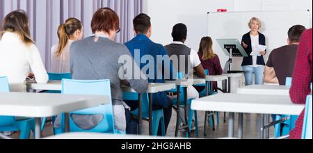 Étudiants travaillant avec un professeur en auditorium Banque D'Images