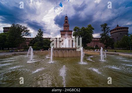 Le Castello Sforzesco, le château de Sforza, situé sur la Piazza Castello, vu au-dessus d'une fontaine, un orage arrive. Banque D'Images