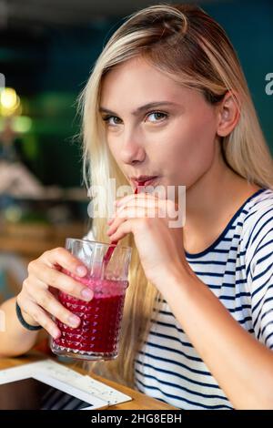 Jeune femme ayant un bon matin boisson saine de smoothie faite de super nourritures.Concept de santé des personnes Banque D'Images