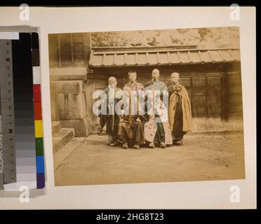 Six hommes, peut-être des moines, pose pour portrait de groupe, quatre et deux assis en face, cinq ont la tête rasée, portant des geta, certains sont maintien des articles, avec des capacités en arrière-plan Banque D'Images