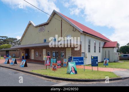 Le Tuncurry Memorial Hall, construit en 1921 à la mémoire de ceux qui se sont battus en WW1, est entouré d'affiches politiques pour voter aux élections locales Banque D'Images