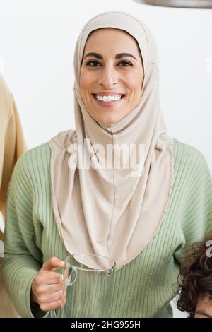 bonne femme musulmane dans hijab tenant la carafe tout en regardant l'appareil photo Banque D'Images