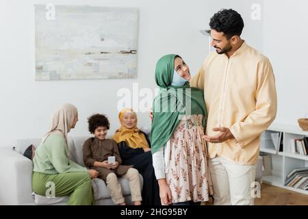 homme arabe parlant à une fille musulmane près d'une famille multiethnique sur un fond flou Banque D'Images