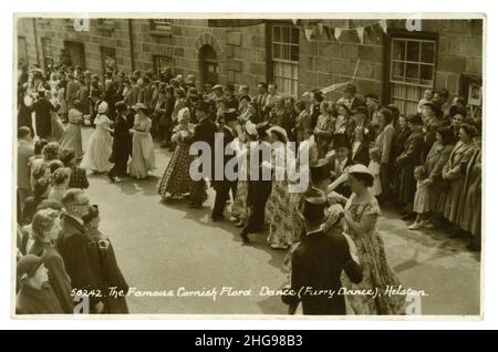 Original des années 1950 salutations carte postale photo de la célèbre Cornouailles de la Flora Day danse (Furry Dance) un festival traditionnel qui remonte à l'époque païenne.Les danseurs sont traditionnellement habillés dans leur meilleur dimanche, les hommes en chemise et cravate et les femmes en robes d'été.Elle célèbre l'arrivée du printemps et se déroule en mai à Helston, Cornwall, Angleterre, Royaume-Uni, le 5 juillet 1952. Banque D'Images