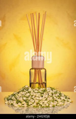 Diffuseur de parfum maison avec bâtonnets de bois et fleurs de jasmin séchées. Banque D'Images