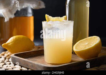 Kombucha biologique maison avec miel, citron et gingembre sur fond noir. Banque D'Images