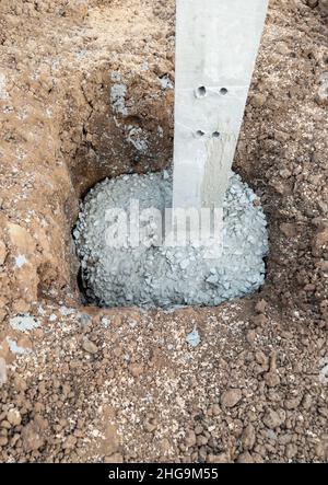 Le ciment a mélangé avec des pierres dans les trous de piliers de béton pour la construction du garage de la maison de campagne, vue de face avec l'espace de copie. Banque D'Images