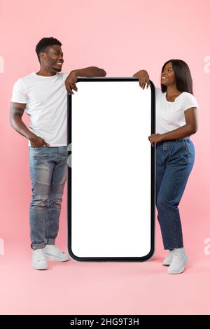 Couple montrant un écran vide blanc de smartphone incliné sur l'écran Banque D'Images
