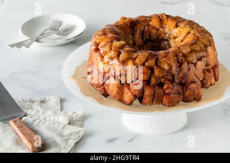 Un pain à la cannelle de pomme est séparé sur un socle avec des plats à servir. Banque D'Images