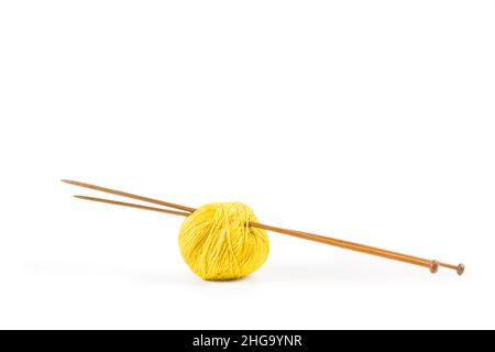 Balles de laine jaune et aiguilles à tricoter sur fond blanc Banque D'Images