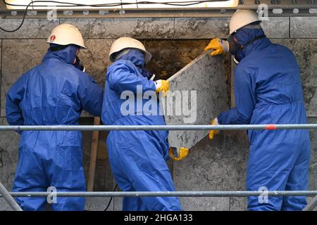 Mayence, Allemagne.19th janvier 2022.Des travailleurs qualifiés de la société spécialisée Reuss Sanierung de Freital retirent une dalle de pierre naturelle du revêtement existant sur l'hôtel de ville de Mayence.Après qu'une dalle sur le bâtiment frappant sur les rives du Rhin s'est détachée l'année dernière, il a fallu la démanteler.Le conseil municipal avait déjà quitté le bâtiment par l'architecte danois Arne Jacobsen (1902-1971) en novembre 2019 en raison de lacunes dans la sécurité incendie.Selon les autorités, la rénovation devrait durer jusqu'en 2027.Credit: Arne Dedert/dpa/Alay Live News Banque D'Images