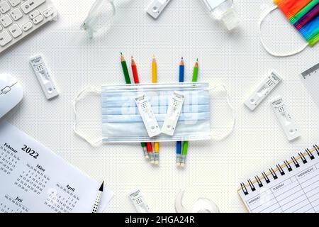 Étude scolaire ou universitaire avec des tests rapides de covid et des masques médicaux.Éducation pendant les pandémies de coronavirus.Calendrier hebdomadaire vide pour planifier les rendez-vous Banque D'Images