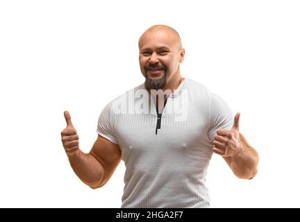 Heureux souriant homme brutal de 40 ans regardant l'appareil photo et en gardant les pouces vers le haut - photo sur fond blanc. Banque D'Images