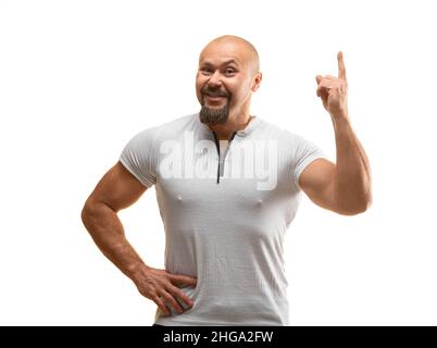 Heureux souriant homme brutal de 40 ans regardant l'appareil photo et gardant le doigt dans l'air - il a une idée géniale - photo sur fond blanc. Banque D'Images