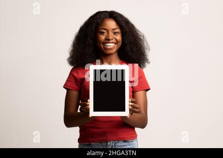 App. FroidJoyeuse African American Female tenant une tablette numérique avec écran vierge Banque D'Images