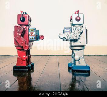 Deux robots rétro face off avec ray guns sur un sol en bois avec réflexion Banque D'Images