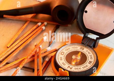 Boussole, allumettes en bois, pipe fumeur et vieux papiers sur le bureau.Concepts de voyage et d'exploration Banque D'Images