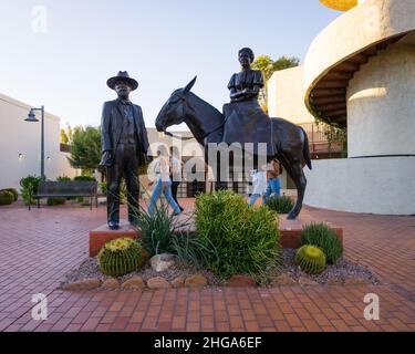 Femmes marchant derrière la sculpture en bronze Winfield Scott Memorial à l'entrée ouest du centre civique de Scottsdale, à Scottsdale, Arizona. Banque D'Images