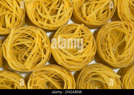 Pâtes italiennes.Spaghetti Capellini isolé sur fond blanc, vue de dessus.Pâtes sous forme de nids. Motif Banque D'Images