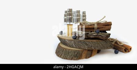 échantillons de parfum sur un support en bois avec de la cannelle sur fond blanc Banque D'Images