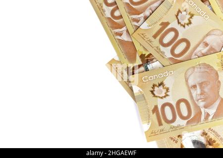 A directement au-dessus de l'image de billets de cent dollars canadiens nets de 100 sur fond blanc.Les billets sont empilés au hasard l'un sur l'autre. Banque D'Images